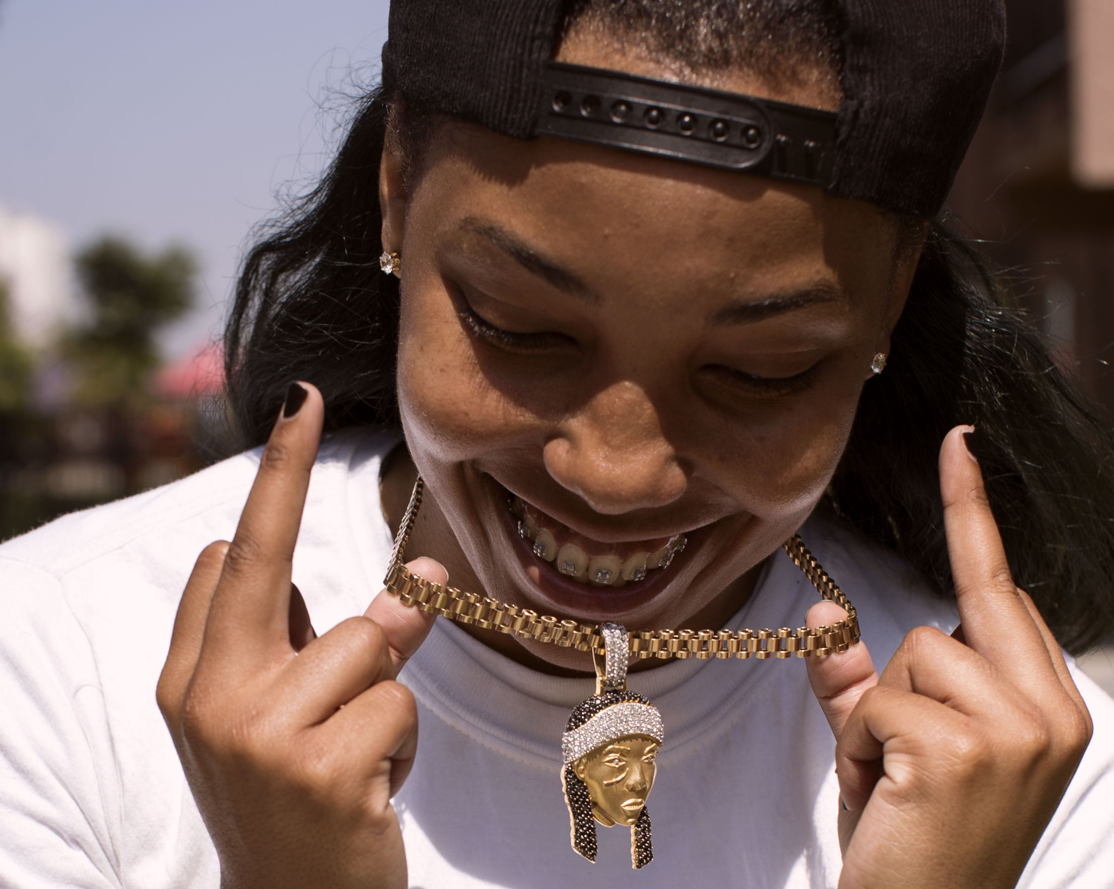 The rapper Azjah holds up her chain